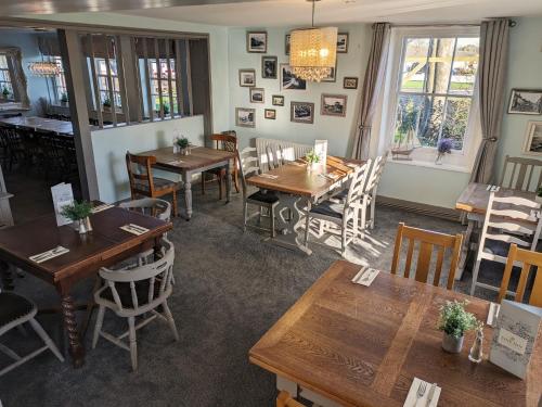 a dining room with wooden tables and chairs at The Ship Inn in Dymchurch
