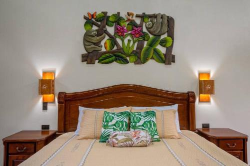 a bedroom with a bed with two lamps and a painting on the wall at Cabañas Refugio Verde Monteverde in Monteverde Costa Rica