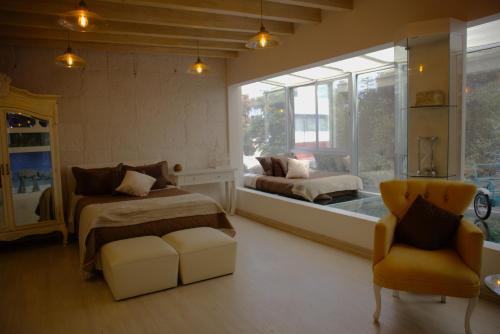 a bedroom with two beds and a chair and a window at Habitación CI Vintage En Coyoacán in Mexico City