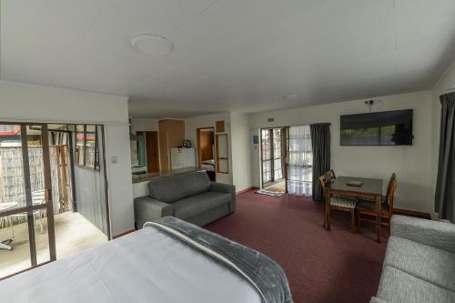 a room with a bed and a couch and a table at Marton Motel NZ in Marton