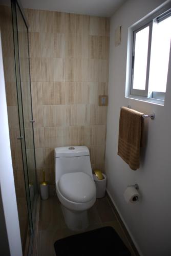 a bathroom with a toilet and a glass shower at Habitación CI Vintage En Coyoacán in Mexico City