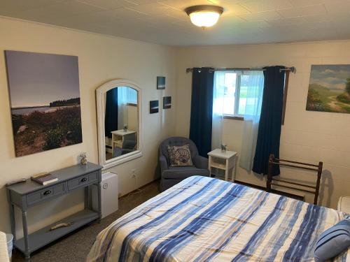 a bedroom with a bed and a chair and a mirror at View Harbor Downtown R and R in Oak Harbor