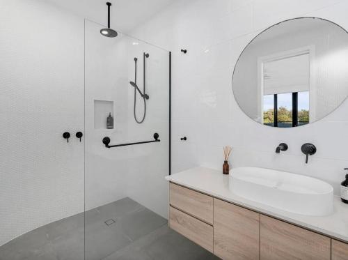a white bathroom with a sink and a mirror at Cylinders Coastal Deluxe in Kingscliff