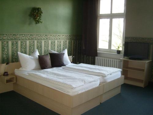1 dormitorio con 1 cama grande con sábanas blancas en Pension Zum Engel, en Magdeburgo