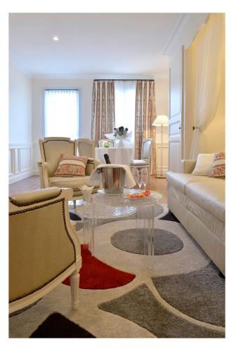 a living room with a couch and a table at Auberge de Cassagne & Spa in Le Pontet