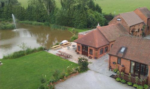 an aerial view of a house next to a lake at Malswick Mill in Newent