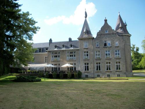 a large stone building with two turrets at Chateau d'Hassonville in Aye