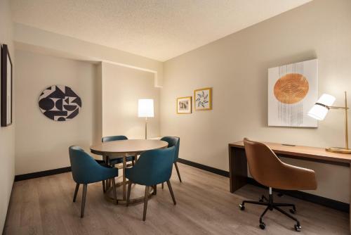 a room with a table and chairs and a desk at Holiday Inn & Suites Vancouver Downtown by IHG in Vancouver