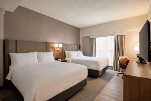 a hotel room with two beds and a television at Holiday Inn & Suites Vancouver Downtown by IHG in Vancouver