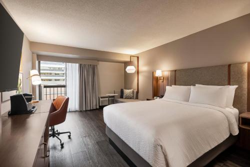 a hotel room with a bed and a desk and a window at Holiday Inn & Suites Vancouver Downtown by IHG in Vancouver