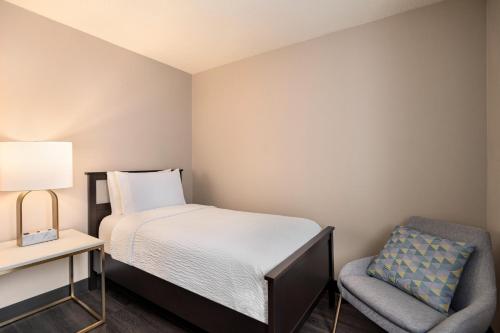a small bedroom with a bed and a chair at Holiday Inn & Suites Vancouver Downtown by IHG in Vancouver