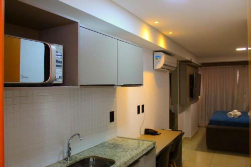 a kitchen with a sink and a room with a bed at Manaíra Apart Hotel by Day by Day *1702* in João Pessoa