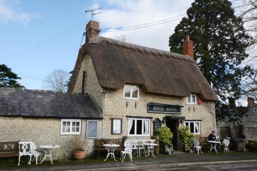 an old building with tables and chairs in front of it at The Old School in Bicester