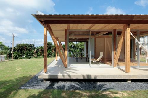 a modern house with a wooden roof at SHINMINKA Villa UTTABARU in Amami