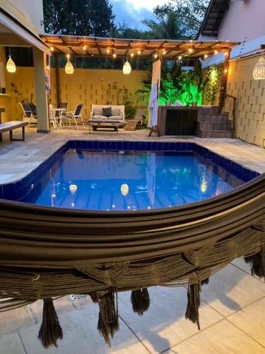 a pool in the middle of a patio with a house at Canto das Laranjeiras MOA in Guarujá