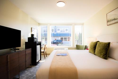 a bedroom with a large bed and a television at The Pathmaker Hotel in Bar Harbor