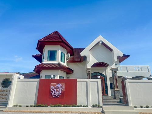 a house with a red sign in front of it at The Star Pool Villa Hatyai in Hat Yai