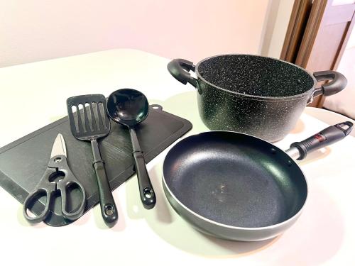 a table with a pan and utensils on a table at 8min walk from Namba Station for 4 people gran704 in Osaka