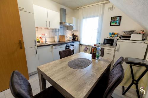 a kitchen with a wooden table and chairs in a kitchen at Hochrhein Ferienwohnung in Albbruck