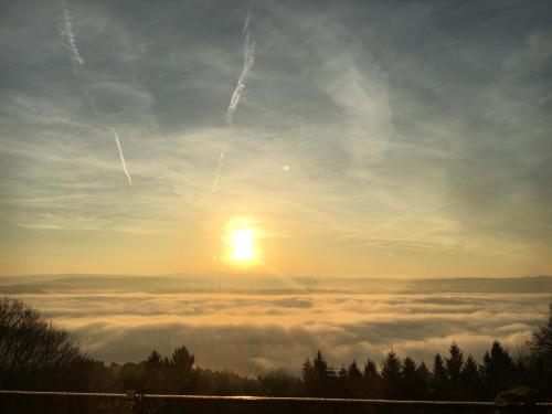a view of the sun rising above a sea of clouds at Berghotel Kockelsberg in Trier