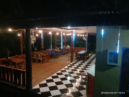 a restaurant with a checkered floor at night at Mega inn tangkahan in Kualagemoh