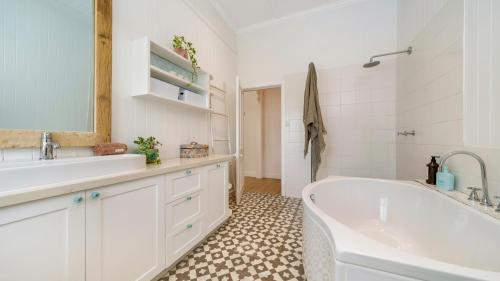 a white bathroom with a tub and a sink at Ananda - Magnificent Byron Hinterland Retreat in Myocum