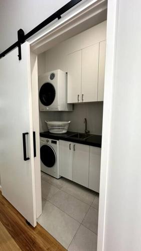 a kitchen with white cabinets and a sink and a microwave at The Escape Home in Repton