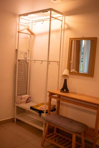 a room with a mirror and a table and a shelf at MARI Suites in Malacca