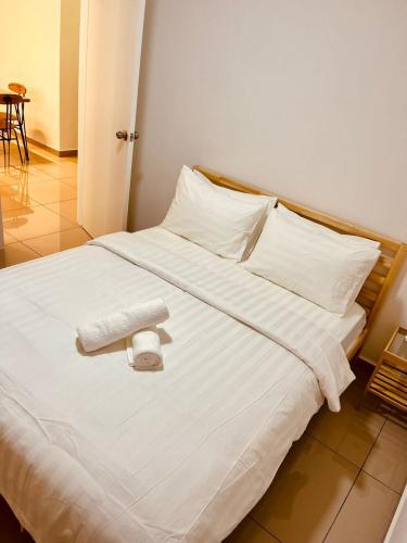 a white bed with two towels on top of it at MARI Suites in Malacca