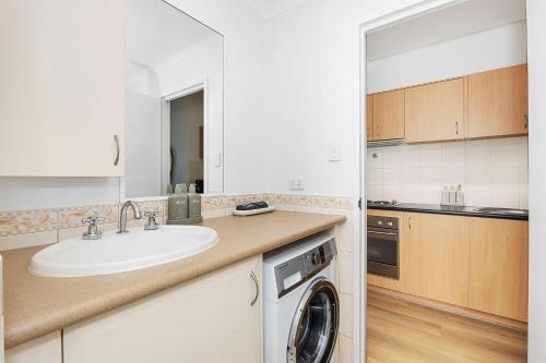 a kitchen with a sink and a washing machine at Small Moments in Perth