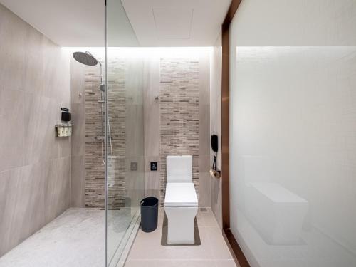 a bathroom with a toilet and a glass shower at Lavande Hotel Wuhan Huazhong University of Science and Technology Jiayuan Road Subway Station Branch in Wuhan