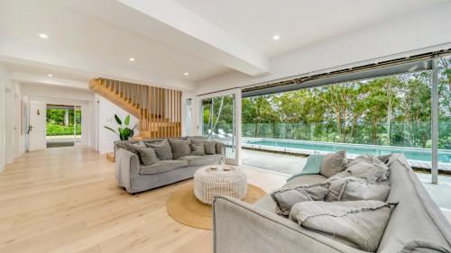 a living room with two couches and a pool at Ananda - Magnificent Byron Hinterland Retreat in Myocum
