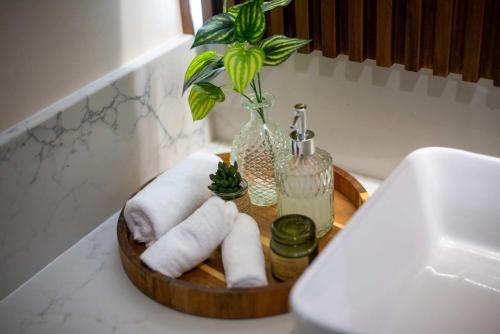 a wooden tray with rolled towels and a vase with a plant at Stunning 2BR with Plunge Pool - Rooftop Sea Views in Playa del Carmen