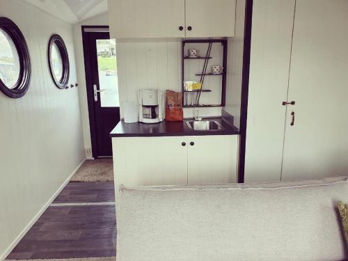 LathumHouseboat in Lathumse Plas with Harbor Views的带白色橱柜和水槽的小厨房