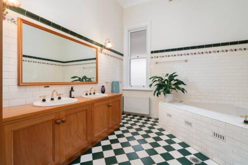 a bathroom with two sinks and a tub and a mirror at Bellisle - 1880's period home in Central Albury in Albury