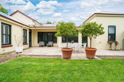 a house with two potted trees in a yard at Bellisle - 1880's period home in Central Albury in Albury