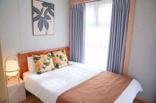 Un dormitorio con una cama y una ventana con cortinas. en Midland Hotel-秋葉原8分4階建て4LDK貸切別荘, en Tokio