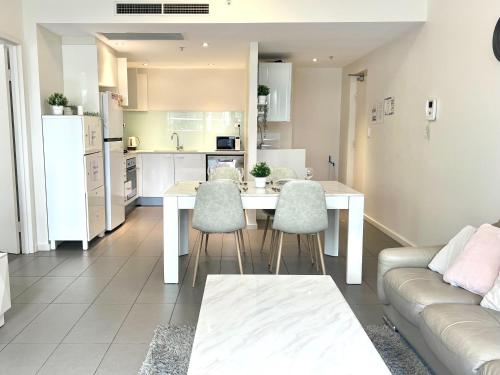 a kitchen and living room with a table and chairs at Charming One-Bed Apt in the Heart of Parramatta in Sydney