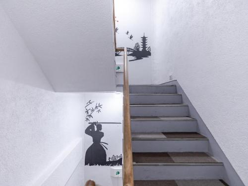 a staircase with a woman in a black dress stenciled at Tabist Hotel Kippaku in Takamatsu