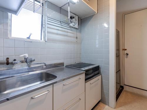 a small kitchen with a sink and a window at Tabist Hotel Kippaku in Takamatsu