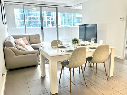 a living room with a table and chairs and a couch at Charming One-Bed Apt in the Heart of Parramatta in Sydney