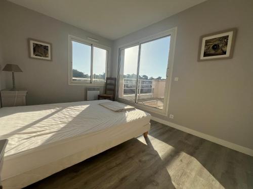 ein Schlafzimmer mit einem Bett und einem großen Fenster in der Unterkunft Appartement 6 pers avec terrasse 80 m², hyper centre, plage à 50m, 296 bd de la plage, Arcachon - FR-1-474-148 in Arcachon