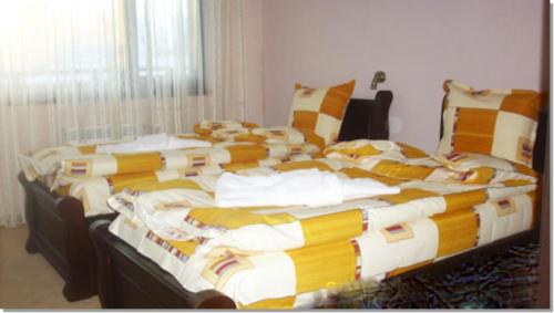 a bedroom with a large bed with colorful blankets and pillows at Family hotel Iskar in Govedartsi