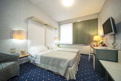 a hotel room with two beds and a tv at Hotel Bisanzio in Ravenna