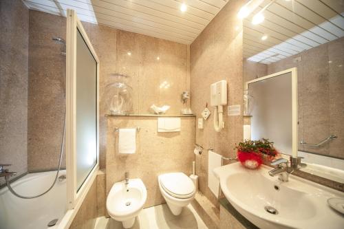 łazienka z toaletą, umywalką i wanną w obiekcie Hotel Bisanzio w Rawennie