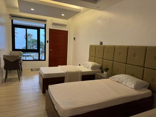 pokój hotelowy z dwoma łóżkami i oknem w obiekcie Villa Lorenzo @ Caliraya Heights Resorts w mieście Halang