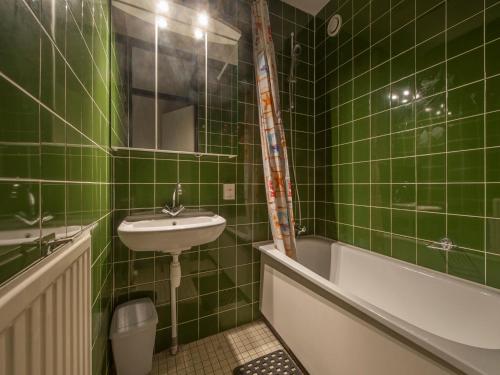 a green tiled bathroom with a sink and a bath tub at Luxe Glamping Getaway in Bruinisse