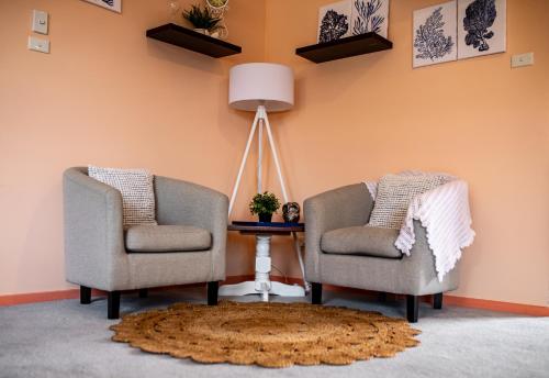 two chairs and a table with a lamp and a rug at Family Beach House Near Barwon River & Beaches in Barwon Heads