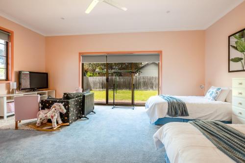 a bedroom with two beds and a sliding glass door at Family Beach House Near Barwon River & Beaches in Barwon Heads