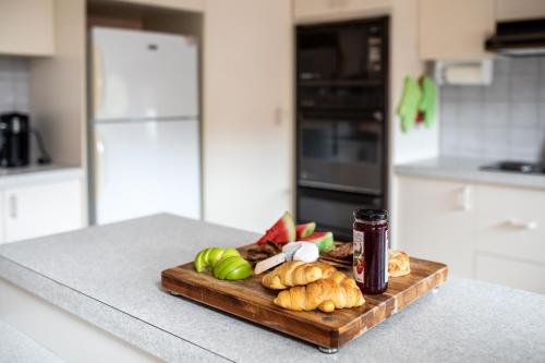 a cutting board with bread and vegetables on a kitchen counter at Family Beach House Near Barwon River & Beaches in Barwon Heads